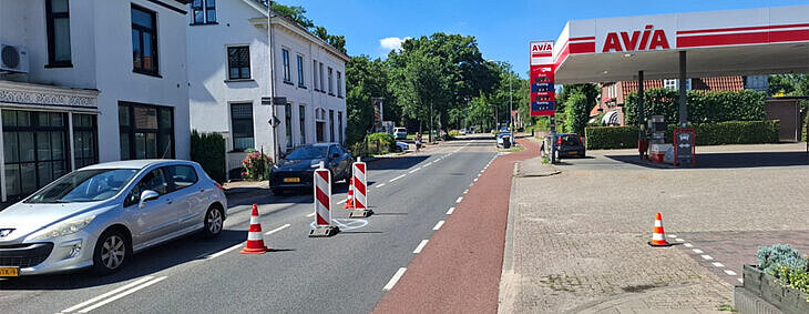 foto van de straat bij het avia tankstation met strakblauwe lucht en pilonnen op de web