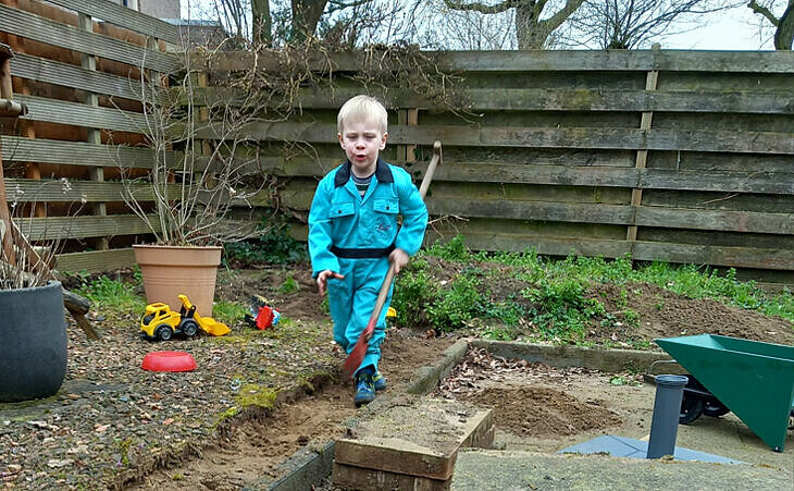kleine jongen bezig met tegels wippen in de tuin.