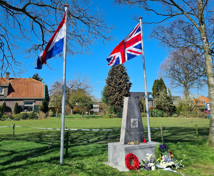 foto van het monument met daarbij Nederlandse en Engelse vlag