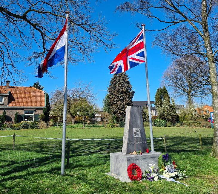 foto van het monument op een zonnige dag met daarbij de Nederlandse en Canadese vlag